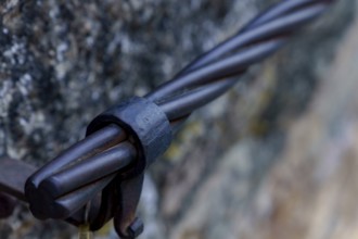 Steel cable railing showing a strong metal connection detail on a stone wall in ronda, malaga,