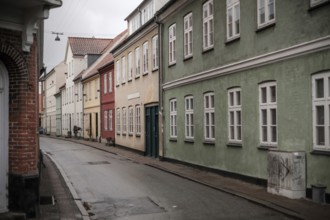 A quiet street with colorful houses and overcast skies in Helsingor, Denmark, Northern Europe