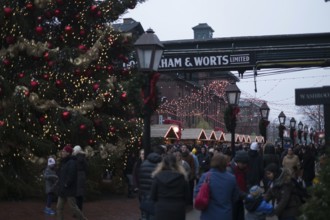A bustling outdoor Christmas market at the Gooderham and Worts Distillery District, with festive