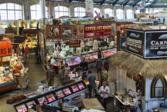 A bustling indoor market at St. Lawrence Market, with meat vendors and colorful displays in