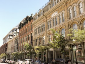 Street view of historic buildings with trees and parked cars in Toronto, Ontario, Canada, North