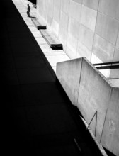 Geometric black and white scene with sharp shadows and a solitary person against a wall in Toronto,
