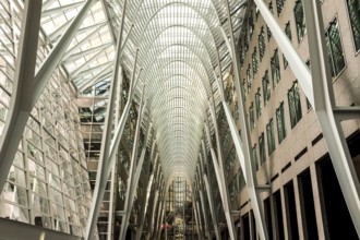 Modern interior of Brookfield Place with a glass ceiling and steel arches creating a symmetrical
