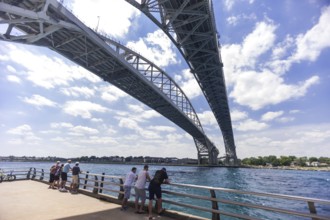 People enjoying the river view underneath the Blue Water Bridge, connecting Canada to the United