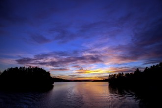 Serene lake at sunset with colorful sky reflections creating a peaceful landscape in Muskoka,