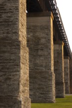 Close-up of a stone bridge in warm light, emphasizing texture and shadows in the industrial