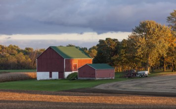 Red barn and fields illuminated by warm sunset in St. Thomas, Ontario, Canada, North America