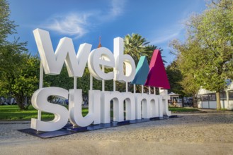 Nov 6, 2024 - Lisbon, Portugal: Large Web Summit sign displayed outdoors in park on sunny day under