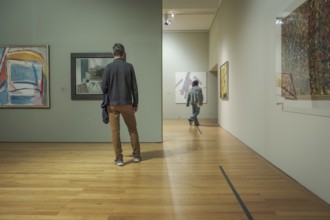 Jan 13, 2024 - Lisbon, Portugal: two visitors explore abstract artworks displayed on walls of