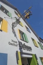 Blue sky, Hotel-Gasthof-Ochsen with nose sign and colourful windows in Kisslegg, Allgäu,