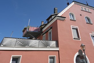 Blue sky, red façade with dormers, chimneys and balcony in Kisslegg, Allgäu, Baden-Württemberg,