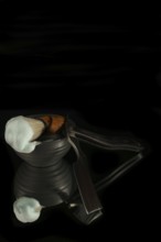 Shaving brush with cream and straight razor reflecting on a black background
