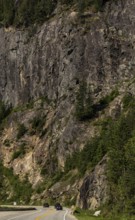 Winding road through a rugged mountainous area with dense forest in Revelstoke, British Columbia,