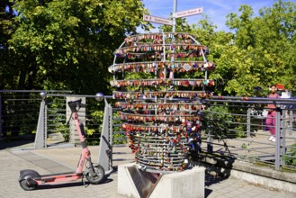 Electric scooter next to a large heart made of padlocks outdoors, Nuremberg, Middle Franconia,