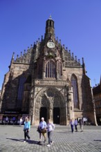 Impressive gothic church facade with people in the city centre under a clear sky, Nuremberg, Middle
