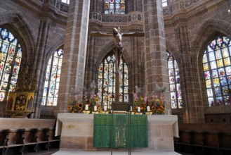 Church altar with cross and colourful stained glass windows depicting biblical scenes, St. Lawrence