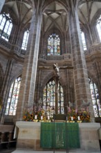 Church altar with cross and colourful stained glass windows in Gothic style, Church of St.