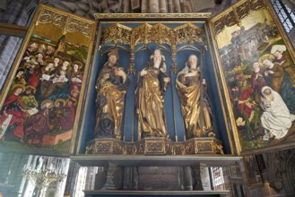 Ornate church altar with gilded figures of saints and colourful paintings, Church of St. Lawrence,