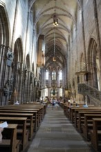 Long nave with high Gothic vaults and people exploring the space, St. Lawrence Church, Nuremberg,