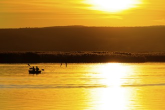 Lake Neusiedl, Burgenland, Austria, Europe, Canoeists on reflecting water in front of a shining,