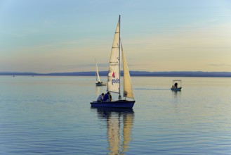 Lake Neusiedl, Burgenland, Austria, Europe, Sailboat at dusk on calm water with gentle waves,