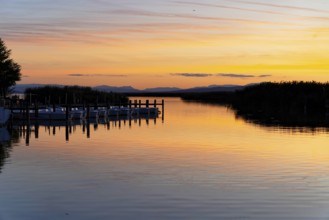 Lake Neusiedl, Burgenland, Austria, Europe, A lake at sunset with quiet boats and a jetty in the