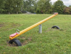 Outdoor playground scenery with Seesaw, lawn and trees