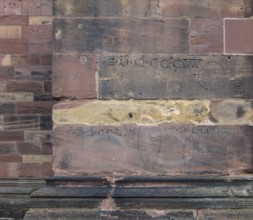 Historic engravings on a stone wall at the Freiburg Minster in Freiburg im Breisgau, a city in
