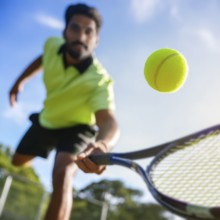 AI generated image showing a flying tennis ball closeup and player in court ambiance