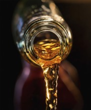 AI-generated close-up image showing a bottle as a clear drink is poured from it, AI generated