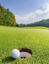 AI generated image showing a golf ball closeup near hole on a golf course