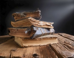 AI generated image showing stacked old rundown books on a wooden table