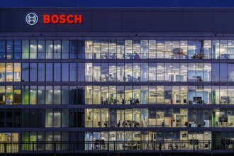 Modern office building of Bosch GmbH in Feuerbach at night with illuminated logo of the automotive