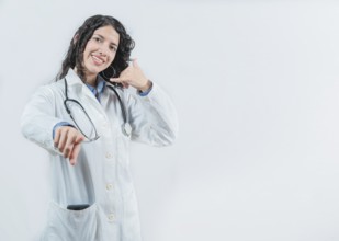 Beautiful female doctor gesturing call isolated. Woman doctor making call gesture and pointing at