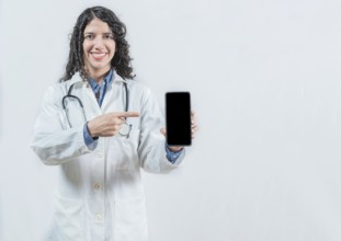 Beautiful woman doctor showing an advertisement on the smartphone screen isolated. Female doctor