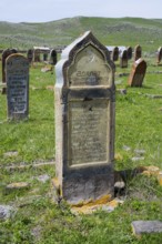 Historic gravestones on a grassy cemetery with hills in the background, old cemetery, Aghvorik,
