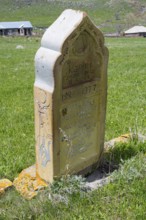Old gravestone on a green meadow in a rural setting in sunny weather, old cemetery, Aghvorik,