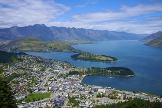 Panorama of a town on the edge of a lake, surrounded by mountains and picturesque landscape,