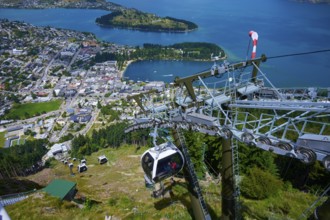 View from a cable car of a town and an expansive lake surrounded by mountains, Queenstown,