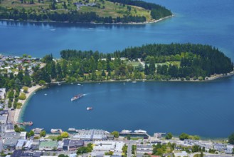View of a bay with a small island, surrounded by the town and natural surroundings, Queenstown,