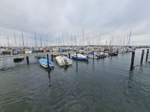 Expansive view of numerous boats in the harbour, surrounded by water and a cloudy sky, Laboe, Kiel