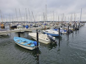Various boats at a jetty in the harbour with cloudy sky and calm water, Laboe, Kiel Fjord,