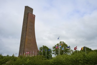 Brick tower with flags surrounded by vegetation, naval memorial, Laboe, Kiel Fjord,