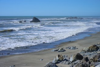 Coastal view with rolling waves meeting a calm beach, West Coast, South Island, New Zealand