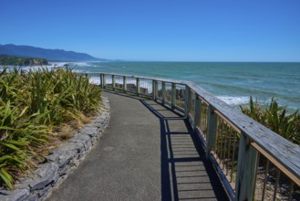 A walkway with railings offers a wide view over the sea and the coastline, Pancake Rocks, Westport,