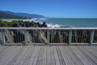 View from a platform with wooden railings of the rugged coastal rocks and the sea, Pancake Rocks,