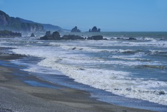 Stormy waves crash against an unspoilt coastline with striking rock formations, West Coast, South