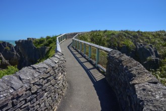 A stone path leads along the cliffs with a picturesque view of the sea, Pancake Rocks, Westport,