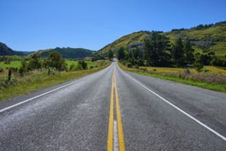 Straight country road with green hills and blue sky, peaceful natural scenery, Buller River,