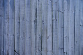 Close-up of a grey wooden fence with vertical panels and distinct texture, West Coast, South